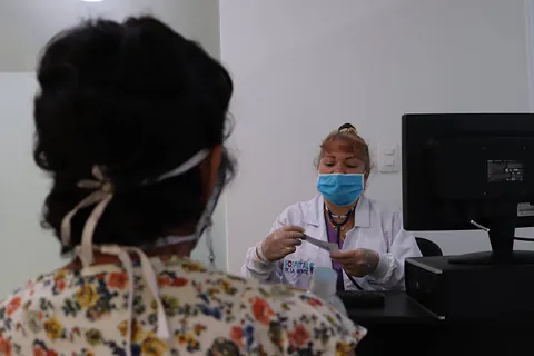 Una médica atiende a una paciente en el consultorio