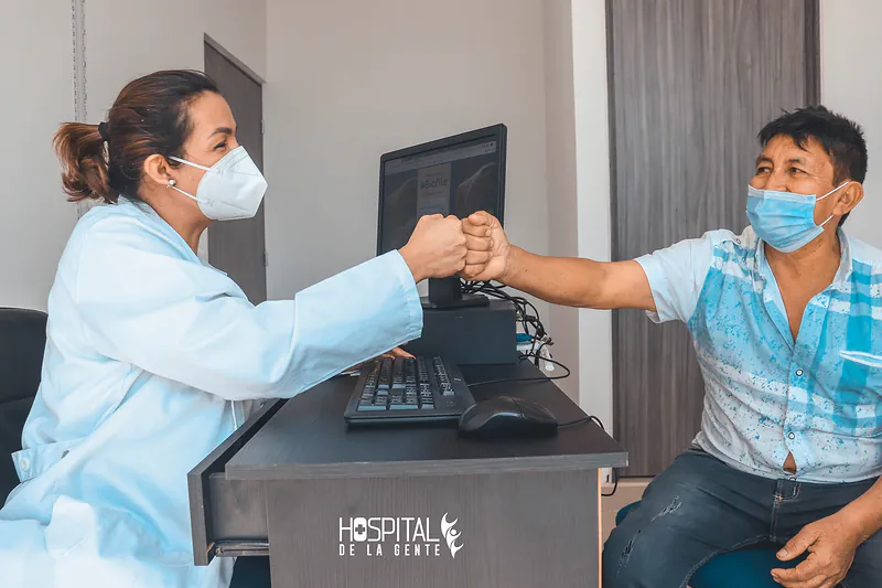 Una médica del hospital choca los puños con su paciente en el consultorio